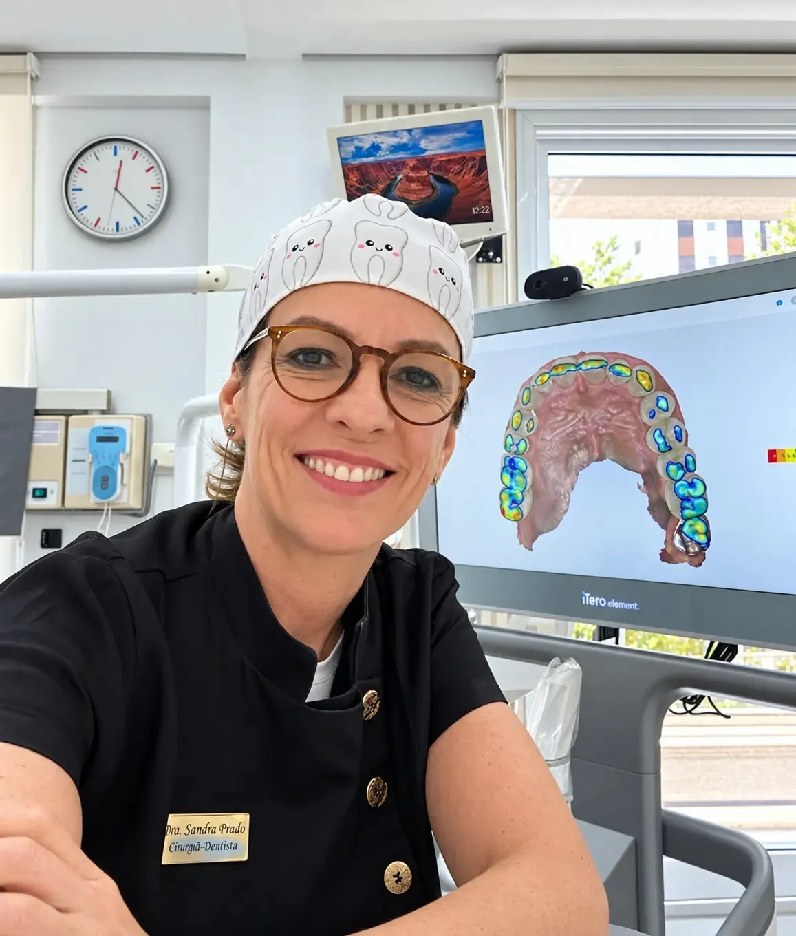 Dra. Sandra Prado no consultório, ao lado da tela do scanner intraoral